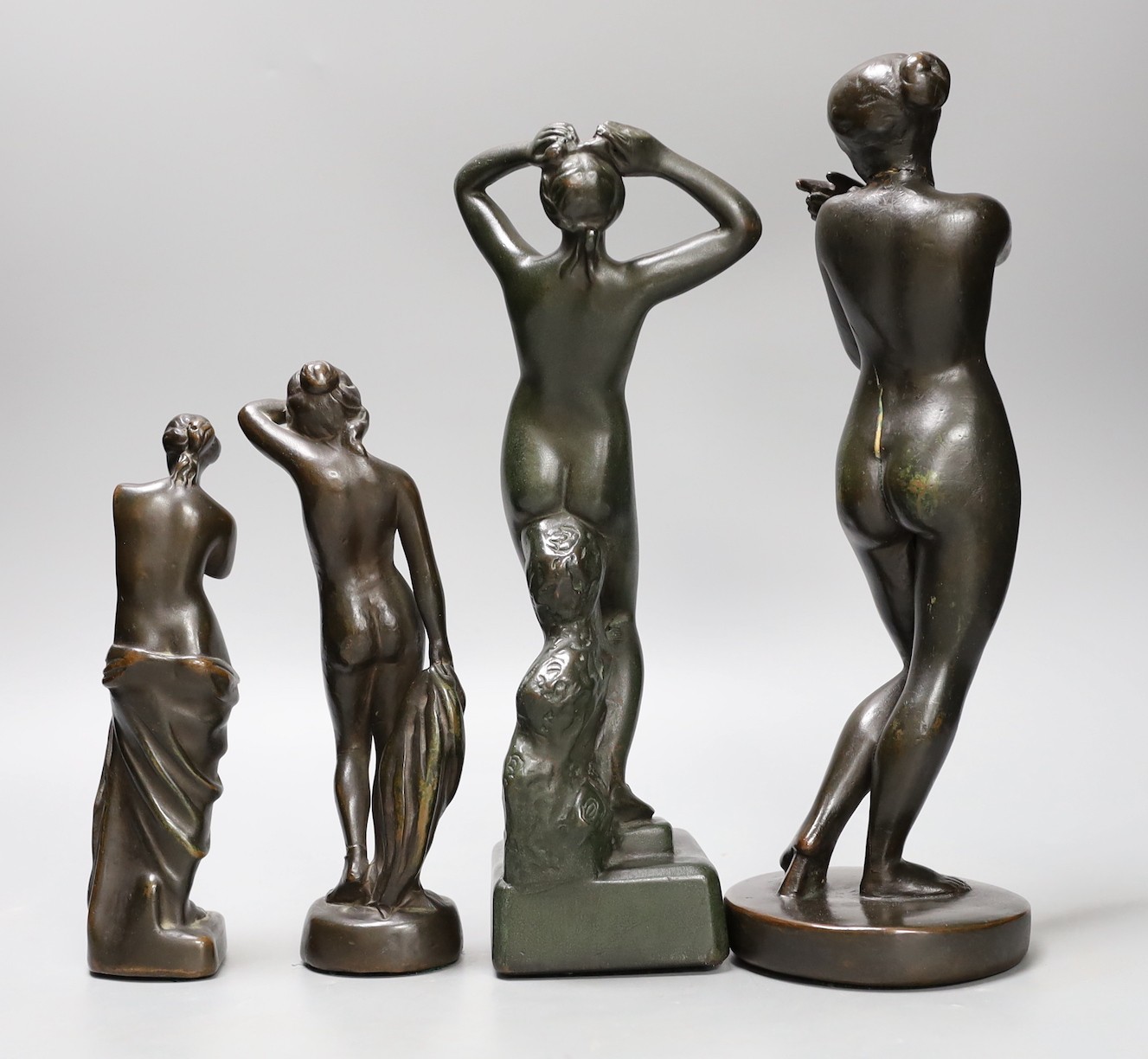 A group of four bronze finished statuettes, tallest 32cm